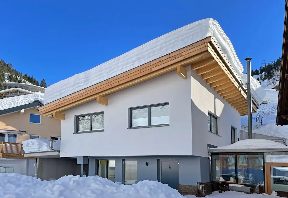 Outside view of a house with lots of snow on its roof