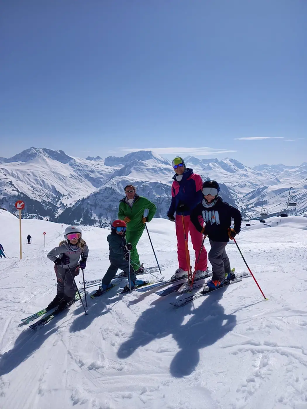 A family skiing on the Arlberg and a beautiful blue sky