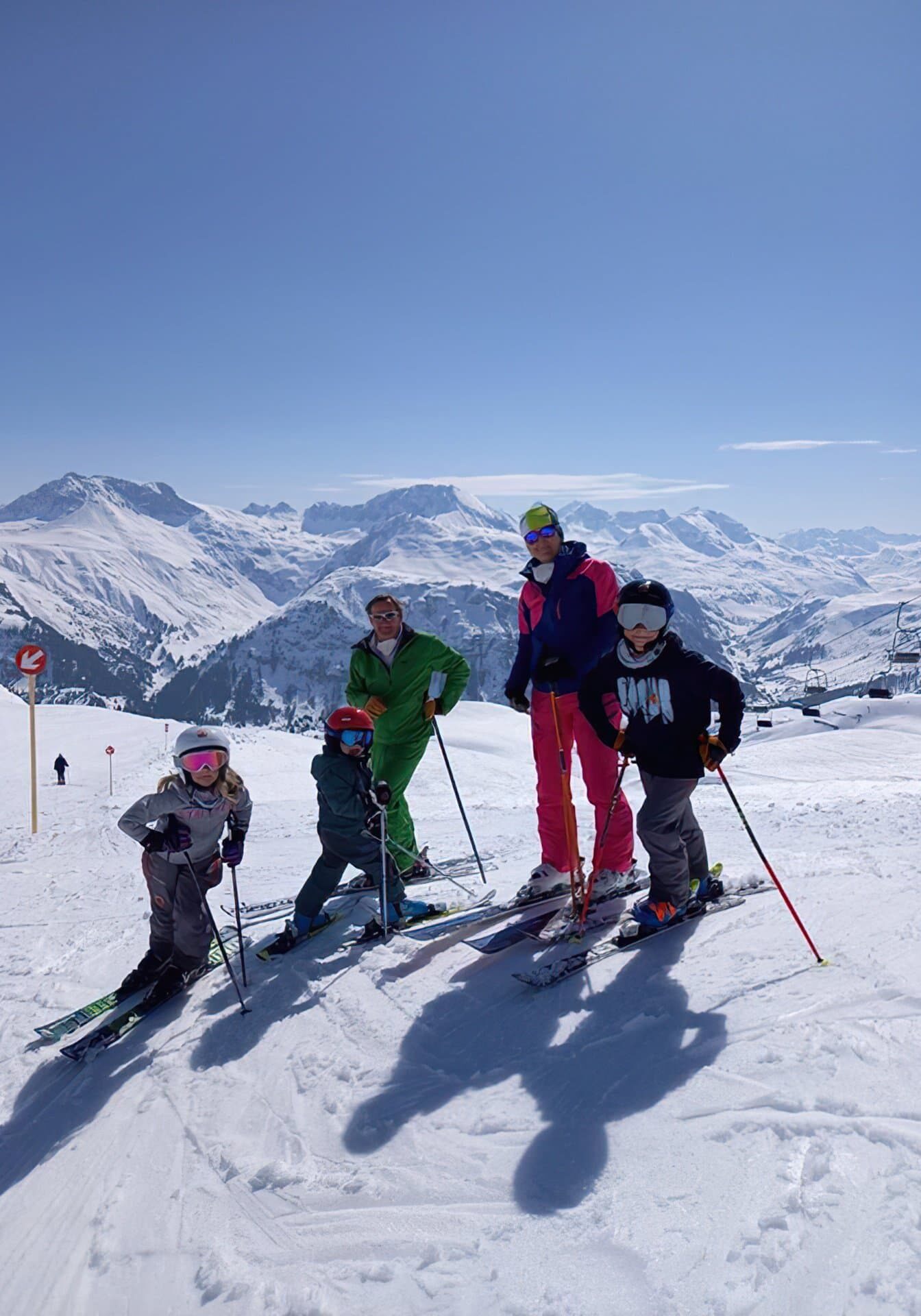 Eine Familie bei Skifahren am Arlberg und wunderschönem blauen Himmel